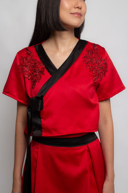 Top vermelho com gola preta e aplicações Jin